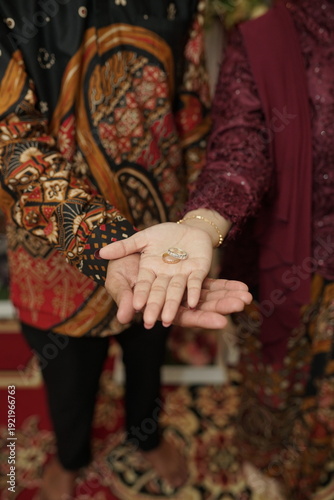 Couple displaying wedding rings on their palms symbolizing unity and commitment on their special day