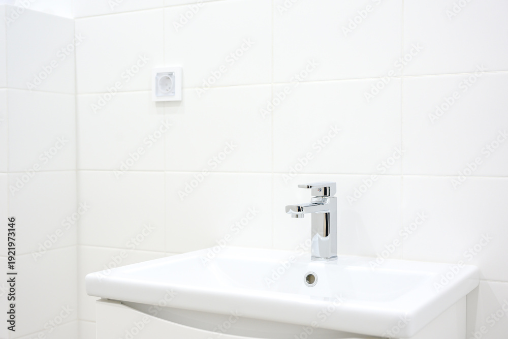 Fototapeta premium Modern bathroom sink with chrome faucet and white tiled wall