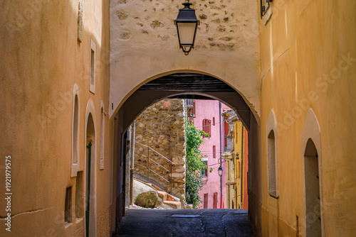 Fotografie Scenic view through a traditional vaulted stone archway, colorful Mediterranean