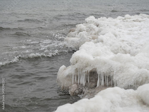 Zamarzniety brzeg morski z krą i soplami lodu