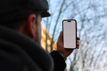 Anonymous man taking a selfie in wooded street