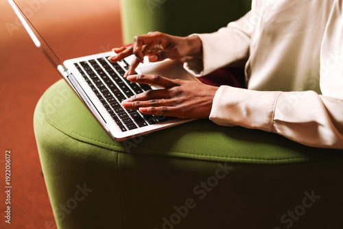 Close-up of hands working on laptop in modern workspace office