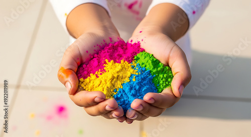Indian children celebrating Holi with joy - Child's hands holding colorful powdered pigments for Holi festival  