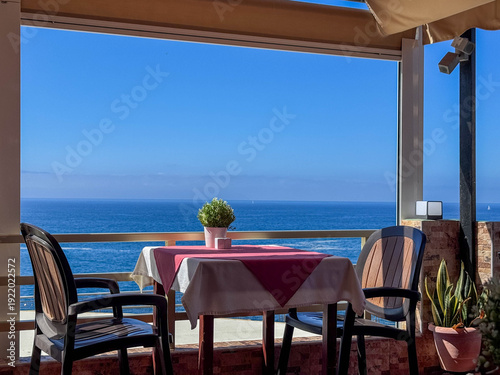 Seaside Terrace Dining Table With Chairs Overlooking Calm Blue Ocean and Horizon View. Guía de Isora, Santa Cruz de Tenerife