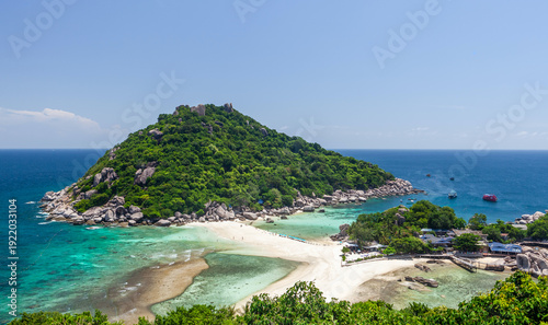 Koh Nang Yuan island with sandy beach and lush greenery. View of turquoise ocean in Thailand. Tropical destination for travel and nature exploration.