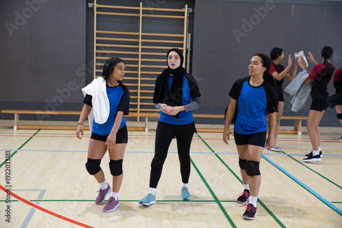 Εκτύπωση καμβά Diverse teen female athletes walking together on school gym court wearing blue s