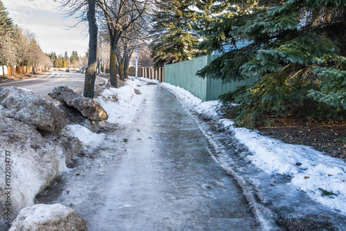Icy sidewalk due to thaw in winter season