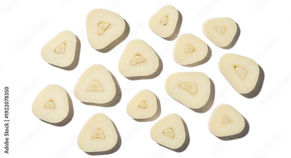 Obraz premium Fresh garlic slices scattered on a bright white background, showcasing their natural texture and culinary readiness for healthy cooking and gourmet dishes