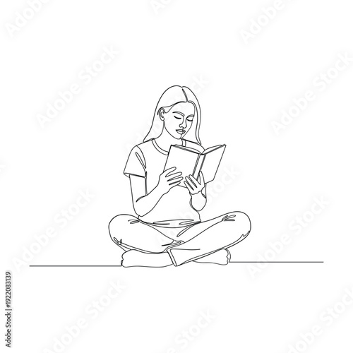 Woman sitting comfortably reading a book with peaceful expression
