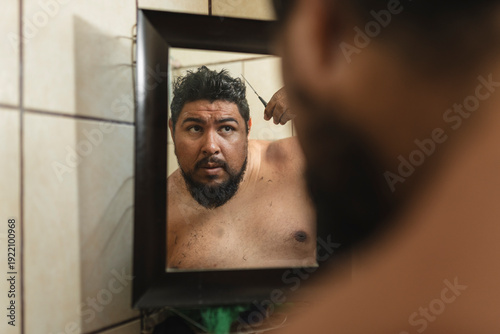 Concentrated man cutting his hair