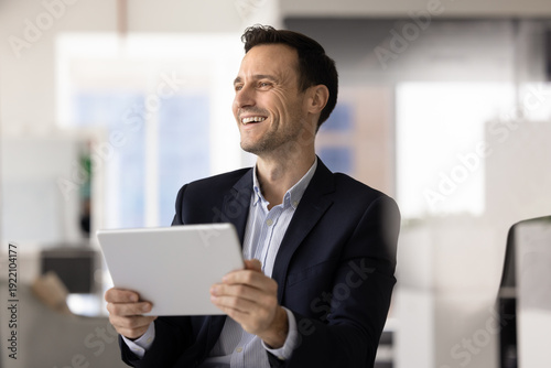 Foto Smiling Hispanic office worker corporate employee holding digital tablet at work