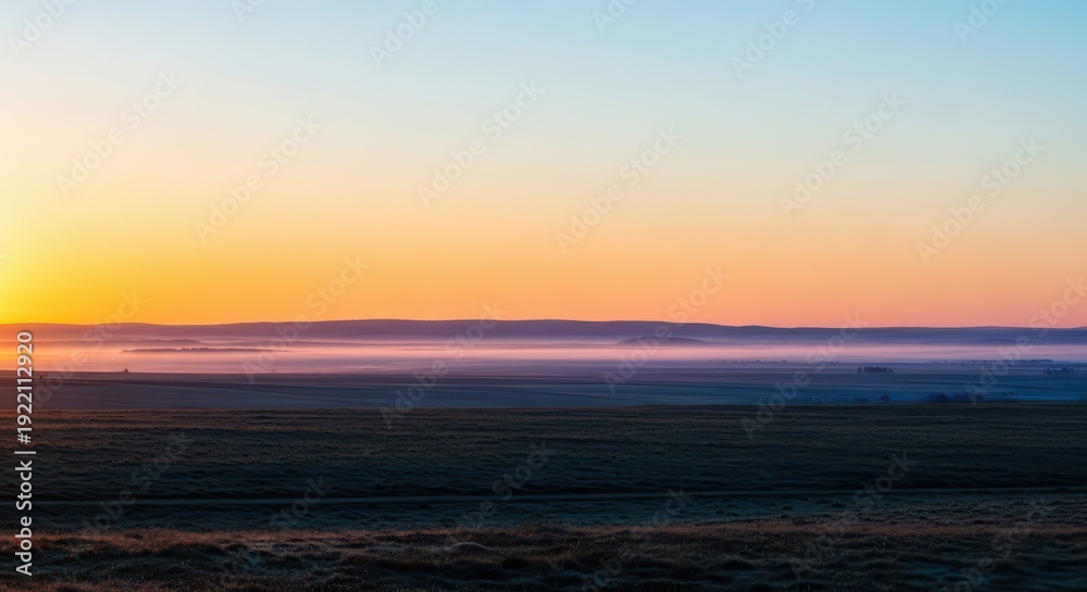 Fototapeta premium The tranquil moment of early morning light breaking over a vast landscape, illuminating the mist and painting the horizon with soft colors, haze, serenity, wide