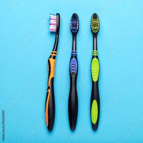 Wallpaper Mural Three colorful toothbrushes arranged on a vibrant blue background, dental hygiene concept. Torontodigital.ca