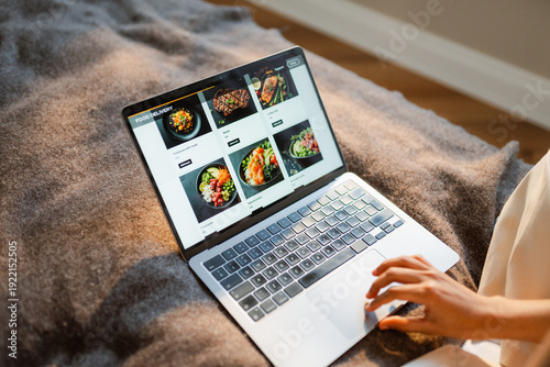 A woman makes an online food order on a laptop