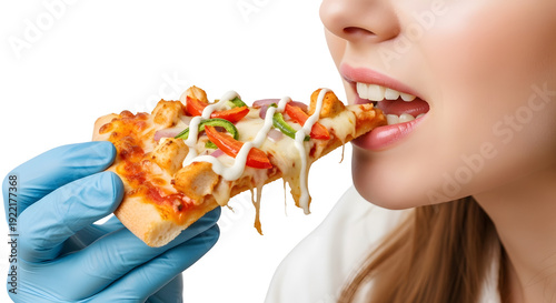 A woman wearing blue gloves eats a slice of delicious chicken pizza.