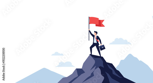 Successful businessman holding a red flag while standing on top of a high mountain peak representing goal achievement.