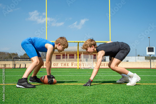 Youth football players facing off at line of scrimmage on outdoor field