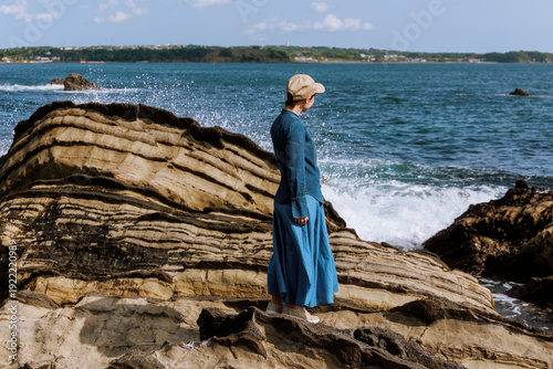 A woman resonating with nature amidst the sound of waves.