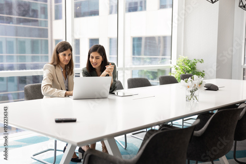Fotografia Two multiracial businesswomen engaged with laptop, reviewing important work docu