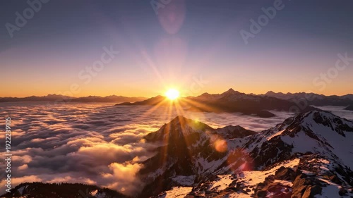 Majestic mountain sunrise over clouds with golden sun rays.