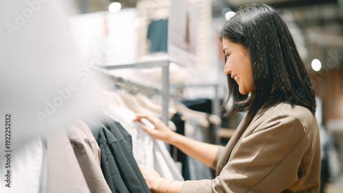 Foto Happy asian business woman shopping clothing shop in department store after work