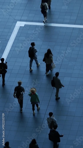 High angle view of people walking along a urban street with blue marks