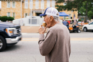 Old Man Enjoying Ice Cream Cone on a Small Town street