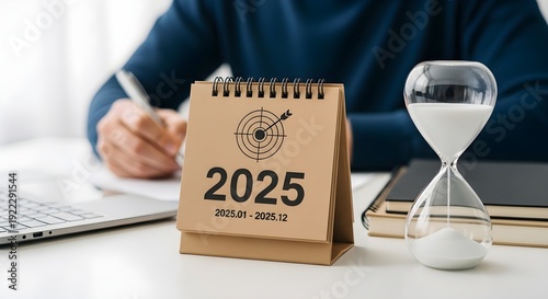 A businessman planning ahead for the year 2025 with a calendar and hourglass
