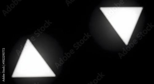Two white triangles on a black background with glowing effect