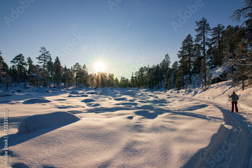 Person cross country skiing on the frozen surface of Lake Inari in Finnish Lapland near Ivalo.