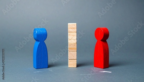Conceptual Image of a Blue and Red Wooden Peg Doll Separated by a Tall Stack of Wooden Blocks on a Dark Grey Background