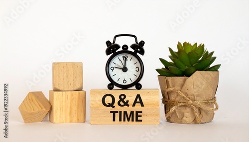 Conceptual Q&A Time Scene Featuring an Alarm Clock on a Wooden Block with Black Text Next to a Potted Succulent Plant and Geometric Shapes to Represent Scheduled Question and Answer Sessions