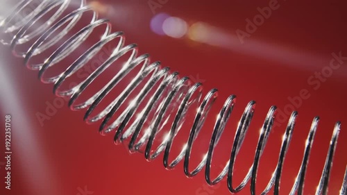 Metal Spiral Coil on Red Surface.