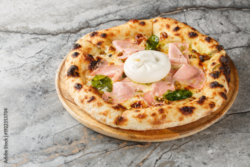 Slika na platnu Oven-baked pizza with burrata and mortadella sausage close-up on a wooden board