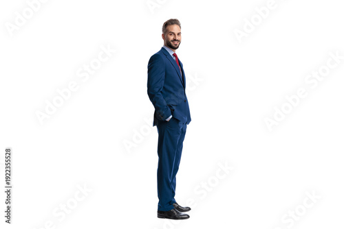 Side view of happy businessman standing with hands in pockets
