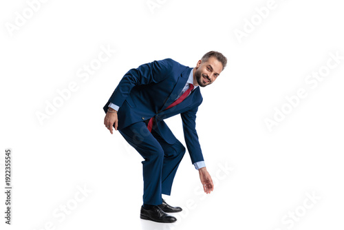 Fotografia Friendly man in suit bending down to pick something up