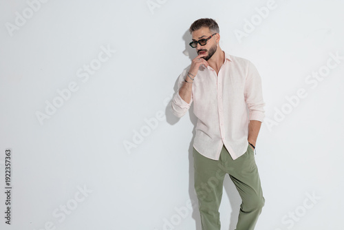 Pensive man touching lip and looking to side