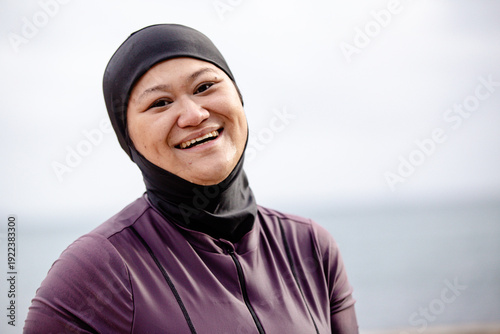 Close up of happy Hmong-American woman wearing black headscarf at the beach