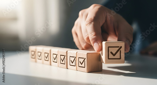 Wallpaper Mural Man Completing Business Process by Placing Final Wooden Block with Checkmark Concept on Light Blur Background Torontodigital.ca