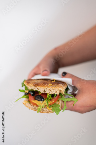 Focaccia with rosemary and salt, filled with tomato, mustard, arugula and olives