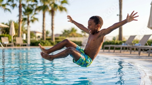 African American boy jumping joyfully into swimming pool on sunny day  