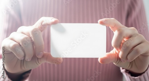 A person holding a blank white business card for customization