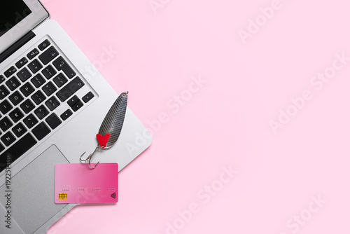 Φωτογραφία Laptop with credit card and fishing hook on pink background