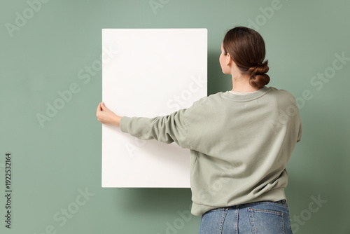 Young woman holding blank p...