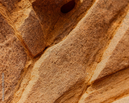 Textured Brown Sandstone Rock Surface with Natural Layered Formations and Earthy Tones