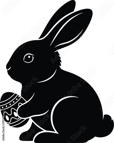 Black silhouette of an adorable easter bunny rabbit holding a decorative painted egg isolated against a clean white background perfect for holiday celebration designs.