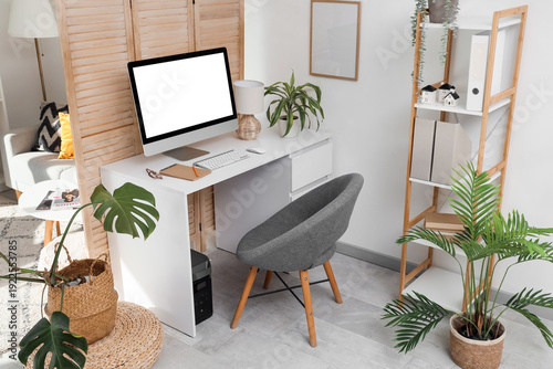 Photography Interior of office with workplace, folding screen and plants
