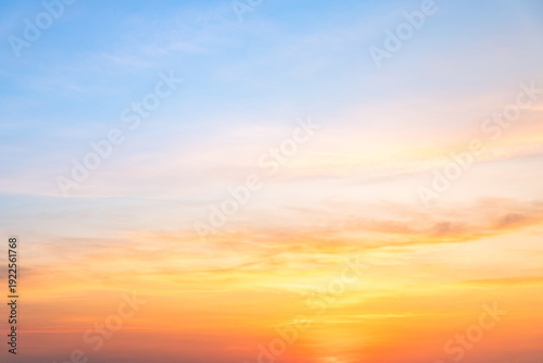 Beautiful sunrise sky with vibrant gradient orange and gold colors and soft blue, Clear atmosphere with wispy clouds. Peaceful, perfect for background and copy space, High resolution images