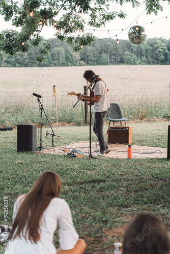 Foto Musician performing at outdoor garden concert for audience