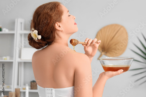 Young woman pouring honey o...
